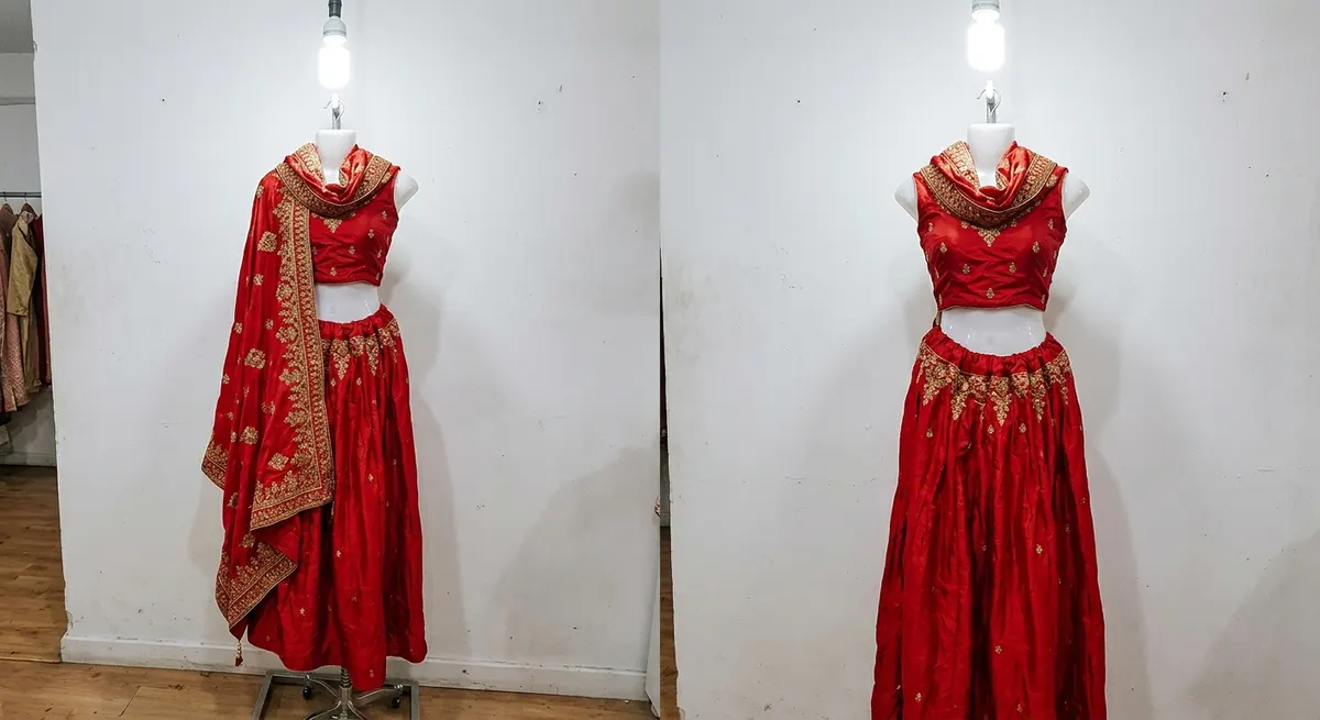 Red silk lehenga on a retail dress form mannequin — typical seller product photo taken with mobile phone under flat overhead lighting, before ShotRoom AI photoshoot